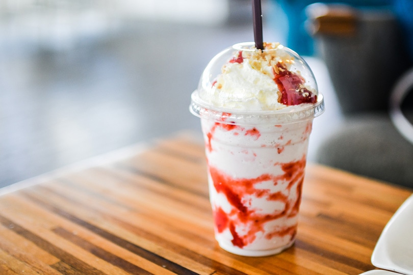 木桌上的草莓芝士蛋糕冰frappuccino