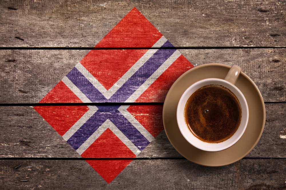 一杯咖啡在木质表面和挪威的旗帜上