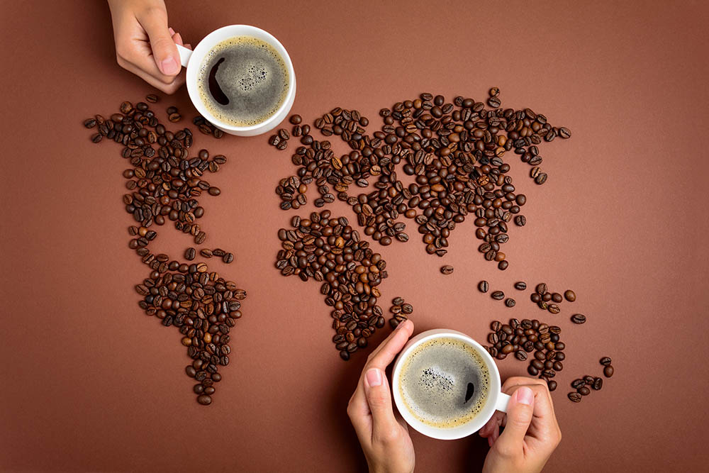 世界地图由咖啡豆和拿着咖啡的人制成