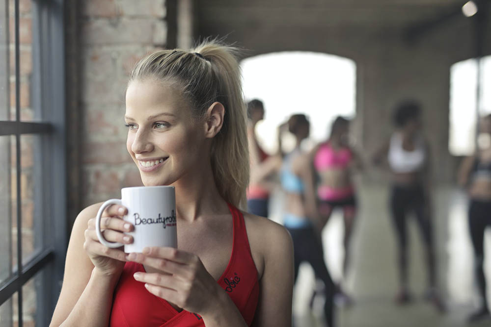年轻女子在锻炼后喝咖啡